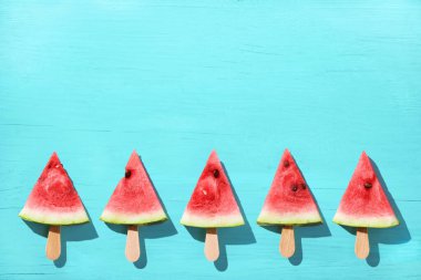 Mavi arkaplanda karpuz dilimleri.