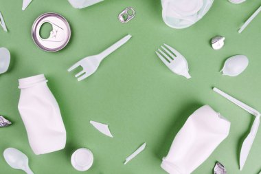 Eko plastik geri dönüşüm konsepti. Yeşil arkaplanda tek kullanımlık plastikler.