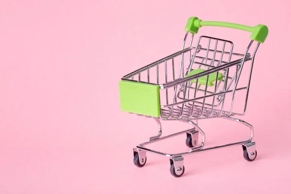 Pusty widok z góry mini różowy koszyk lub wózek zakupy na różowym tle — Zdjęcie stockowe