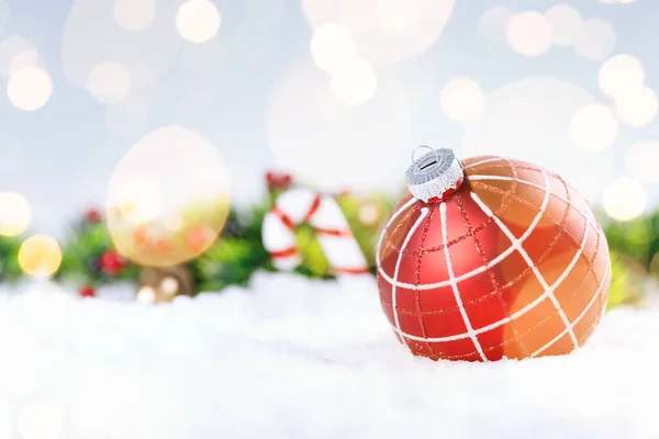 Bola de Navidad y ramas de abeto con decoraciones en la nieve. — Foto de Stock