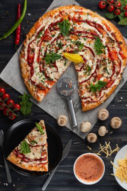 Geleneksel İtalyan pizza, sebze, malzemelerin koyu arka plan üzerine. Pizza fırında pişiyor.