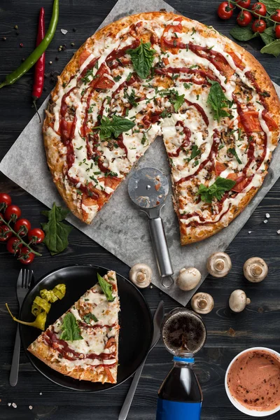 Geleneksel İtalyan pizza, sebze, malzemelerin koyu arka plan üzerine. Pizza fırında pişiyor.