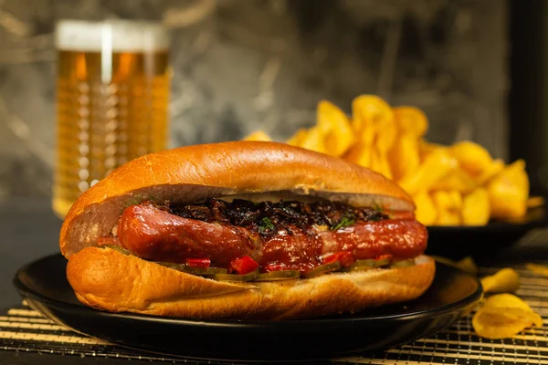 Sosis bardak bira ile ahşap tahta üzerinde patates kızartması ile