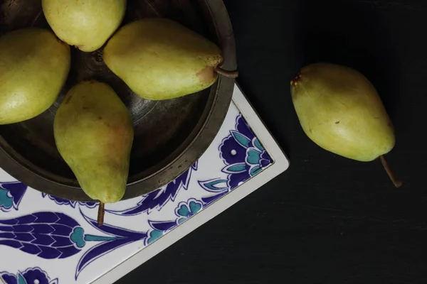 在黑色背景下的盘子里的梨 — 图库照片