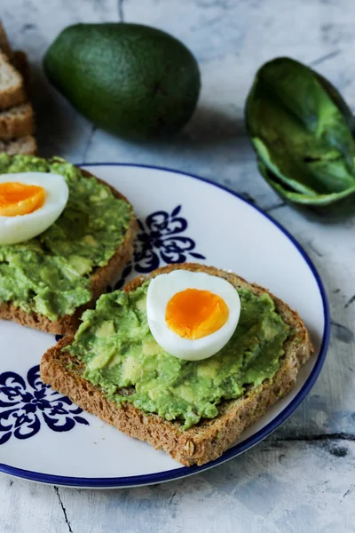Toast with avocado and egg, bread slice with egg and avocado