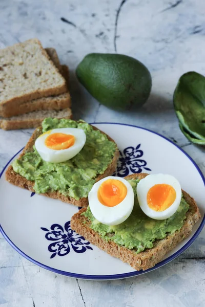 Toast with avocado and egg, bread slice with egg and avocado