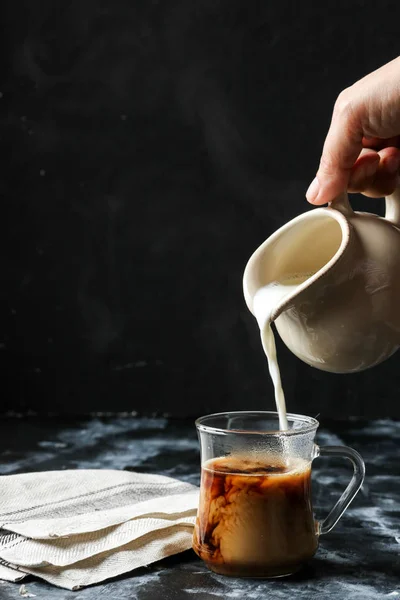 Kobieta Ręką Mleko Spływał Szklanki Kawy — Zdjęcie stockowe