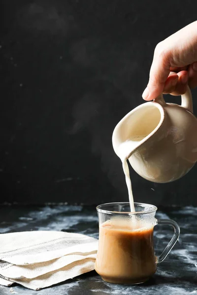 Kobieta Ręką Mleko Spływał Szklanki Kawy — Zdjęcie stockowe