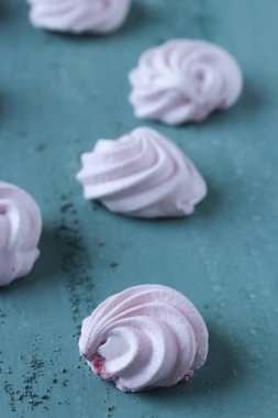 yeşil arka planda pembe Meringues çerezleri