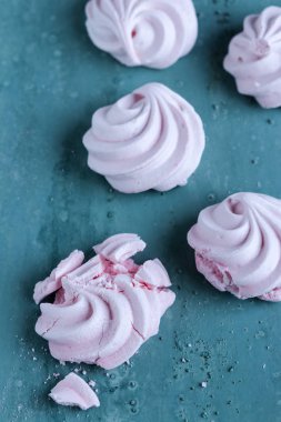 yeşil arka planda pembe Meringues çerezleri