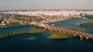 Drone görünümü 4k Yanlara uçan kamera, arabaların çarptıği suyun üzerindeki köprüye doğrudan bakıyor
