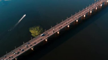 Drone görünümü 4k o giden araba üzerinde bir daire içinde su üzerinde köprü daire