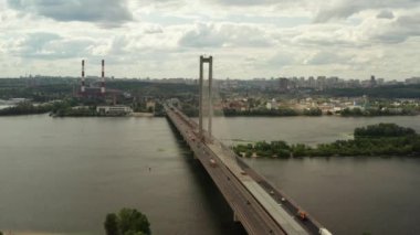Aerial Shot drone görünümü Kiev güney köprüsü boyunca uçan, Ukrayna, etrafında bir çim araba ve su nerede