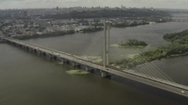 Aerial Shot drone görünümü Kiev güney köprüsü boyunca uçan, Ukrayna, etrafında bir çim araba ve su nerede