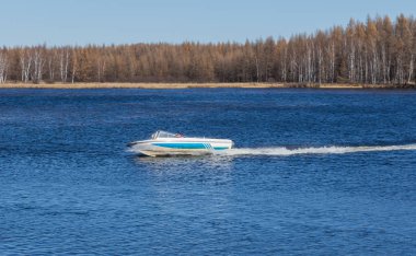 Sakin gölde, yüksek hızlı sürat teknesi turistleri hızlı bir şekilde kaydırıp insanlara mutluluk getiren,