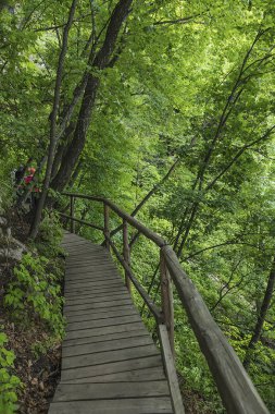 Jilin Eyaleti, Çin'de Hanging Kettle Tourist Resort ahşap tahta yolda, tahta yol dağlar tarafından ormanlar arasında inşa edilmiştir. Tahta yolda yürümek, insanların her zaman dağlara ve nehirlere entegre olduğunu gösteriyor..