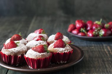 Ahşap bir masa üzerinde taze çilek ile cupcakes