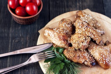 Kızarmış tavuk kanadı bir rustik hizmet yönetim kurulu, siyah ahşap zemin üzerinde