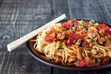 Spagetti domates soslu tavuk, domates, maydanoz üzerinde ahşap bir masa ile dekore edilmiş