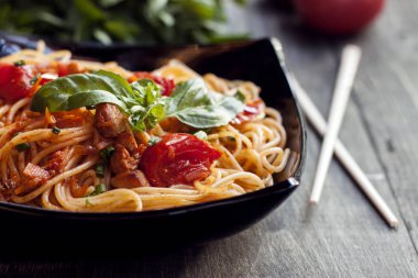 Spagetti domates soslu tavuk, domates, maydanoz üzerinde ahşap bir masa ile dekore edilmiş