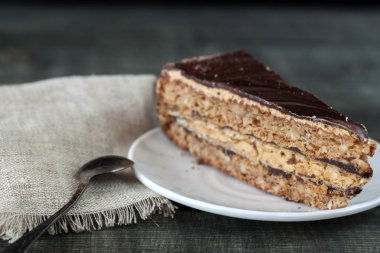 Ahşap bir masa üzerinde bir dilim pasta beyaz bir plaka üzerinde olduğunu