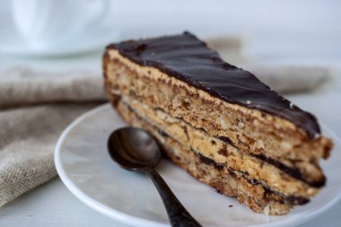 Ahşap bir masa üzerinde bir dilim pasta beyaz bir plaka üzerinde olduğunu