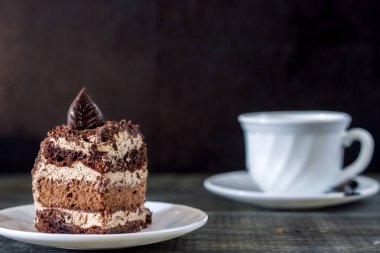 Ahşap bir masa üzerinde bir dilim pasta beyaz bir plaka üzerinde olduğunu