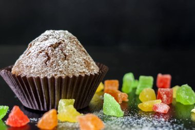 Şekerlenmiş meyve siyah bir tablo ile cupcakes