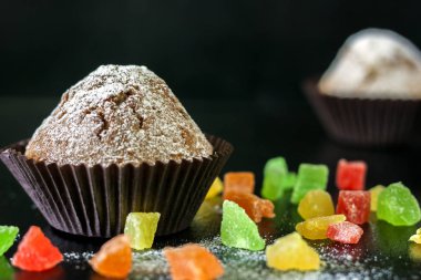 Şekerlenmiş meyve siyah bir tablo ile cupcakes