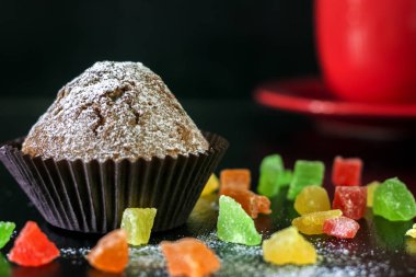 Şekerlenmiş meyve siyah bir tablo ile cupcakes