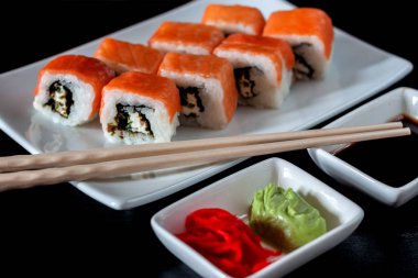 Philadelphia suşi rulo yapılmış taze somon, avokado ve krem peynir ile içinde mürekkep balığı mürekkep siyah pirinç ile. Geleneksel Japon mutfağı. Asya gıda