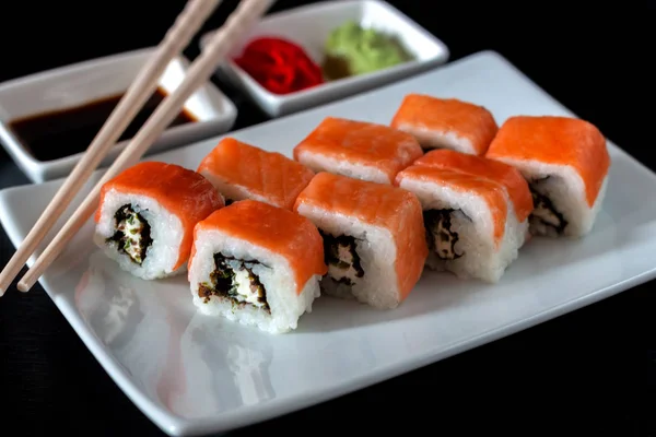 Philadelphia Sushi Roll made of Fresh Salmon, Avocado and Cream Cheese with black rice with cuttlefish ink inside. Traditional Japanese cuisine. Asian food
