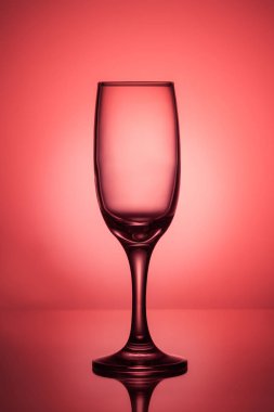 Parlak spot Center'da bir kırmızı zemin üzerine boş şarap kadehi