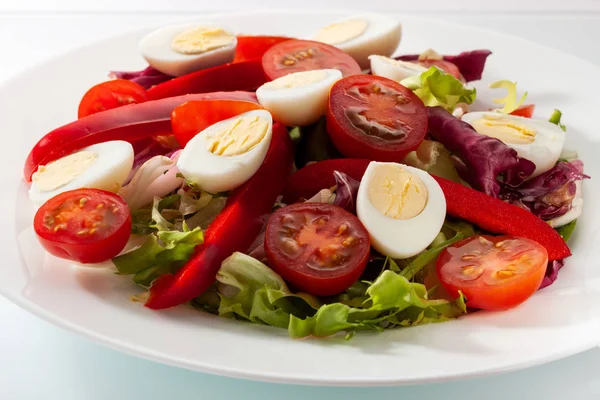 Salada com verduras frescas em uma mesa branca — Fotografia de Stock