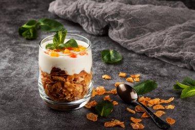 Koyu gri arka planda bir cam bardak Mısır gevreği