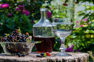 Eski bir ahşap masadan avza cam çilek ile frenk üzümü şarap