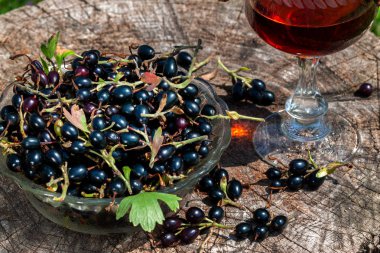 Eski bir ahşap masadan avza cam çilek ile frenk üzümü şarap