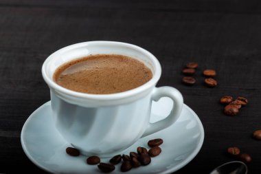 Siyah ahşap bir masada kahve fincanı