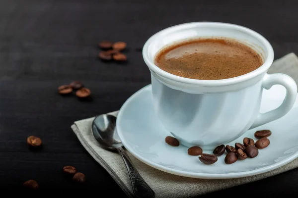Cup of coffee on a black wooden table — Stock Photo, Image