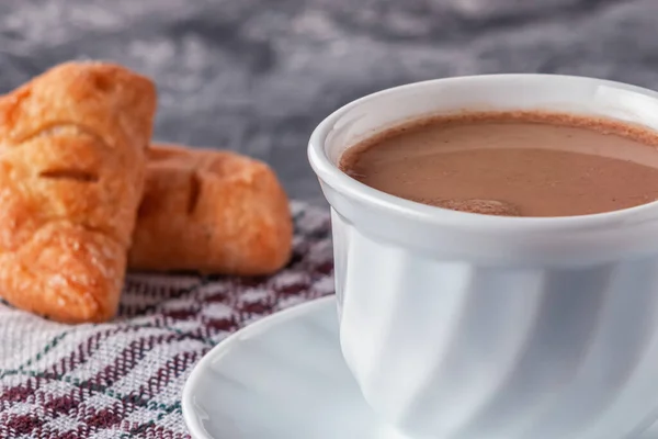 Кофе со сливками и свежеиспеченные слойки на сером фоне — стоковое фото