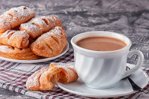 Kaffee mit Sahne und frisch gebackenen Blättern auf grauem Hintergrund — Stockfoto