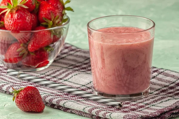 Smoothie aux fraises avec lait dans un verre sur fond vert, alimentation saine pour le petit déjeuner et collations — Photo