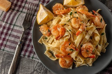 Gri arka planda karides ve maydanozlu tagliatelle