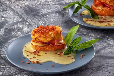 Jambon ve soslu tost ekmeğine Benedict usulü yumurta.