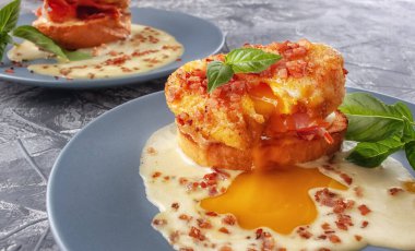 Jambon ve soslu tost ekmeğine Benedict usulü yumurta.