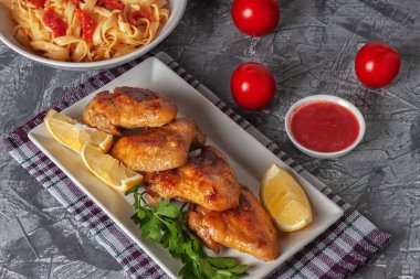 Domatesli, limonlu ve maydanozlu taze kızarmış tavuk kanadı.