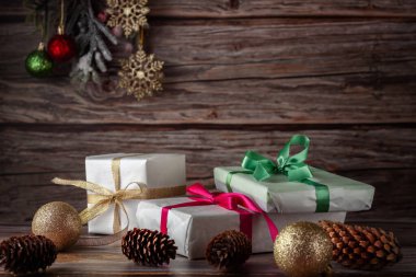 Noel kompozisyonu. Noel arkaplanda küçük hediyeler, kurdeleler, Noel baloları ve köknar dalları