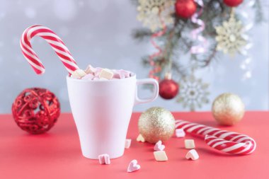 Beyaz bir masada latteli bir bardakta şekerlemeler.