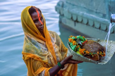 Indian Hindu woman devotee offering prayers to the Sun God during Chhath Puja in Varanasi clipart