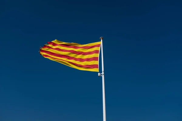 Zbliżenie katalońskiej flagi pływające na błękitnym niebie. — Zdjęcie stockowe